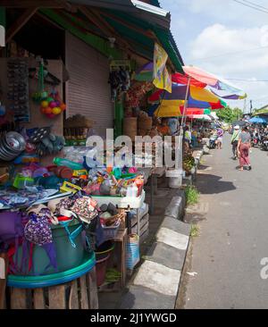 Eine Straße voller Geschäfte, die Küchengeräte, Eier, Gemüse und viele andere im Sukawati Markt, Bali, Indonesien, verkaufen. Stockfoto