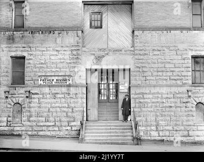 Mann auf den Stufen der Friedensmission von Pater Divine, Harlem, New York City, New York, USA, Edwin Rosskam, U.S. Farm Security Administration/U.S. Office of war Information, Dezember 1941 Stockfoto