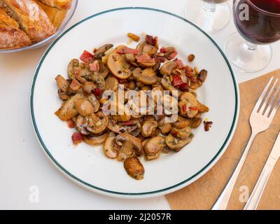 Sautierte Pilze auf weißem Teller serviert Stockfoto