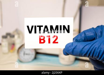 Arzt mit einer Karte mit Vitamin B12, medizinisches Konzept. Stockfoto