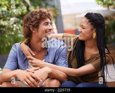 Wahre Liebe. Aufnahme eines liebevollen jungen Paares, das im Freien sitzt. Stockfoto