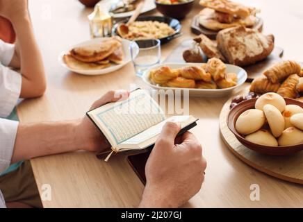 Muslimische Familie betet vor dem Frühstück zusammen. Feier von Eid al-Fitr Stockfoto