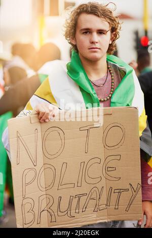 Wir hatten genug. Porträt eines jungen Protesters mit einem Schild gegen die Polizeigewalt bei einer Kundgebung. Stockfoto