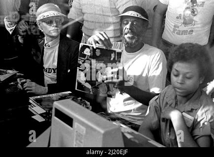 Eine Veranstaltung, die im Hollywood Outlet als „Amos und Andy“ für die berühmten Amos Cookies, Andy Warhol und Wally Amos bezeichnet wird, signiert Bücher neben einer Kasse. Los Angeles, Kalifornien, 1979. Stockfoto