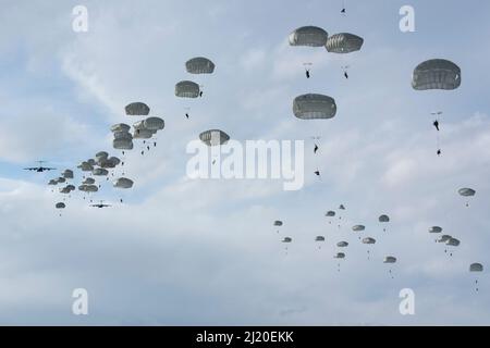 Fallschirmjäger der Armee des Kampfteams der Infanterie-Brigade 4. (Airborne), 25. Infantry Division, U.S. Army Alaska, steigen nach einem Sprung von der US Air Force C-17 Globemaster IIIs über die Malemute Drop Zone während eines Flugtrainings auf der Joint Base Elmendorf-Richardson, Alaska, ab, 24. März 2022. Flieger vom 62. Luftlift Wing, Joint Base Lewis-McChord, Washington, 176. Wing, JBER, Alaska und der 514. Air Mobility Wing, Joint Base McGuire-Dix-Lakehurst, New Jersey, stellten Fluganlagen für die Ausbildung bereit. Armee- und Luftstreitkräfte trainieren regelmäßig zusammen, um die gemeinsame Mission readin zu stärken und aufrechtzuerhalten Stockfoto