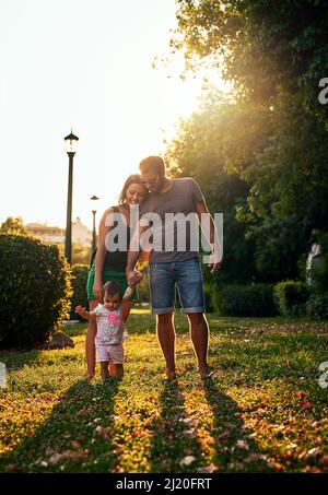 Zwei plus eins entspricht Familie zu uns. Aufnahme einer jungen Familie im Freien. Stockfoto