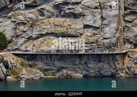 Radfahrer auf Freischwinger Brücke auf Lake Dunstan Radweg, und Lake Dunstan, in der Nähe von Cromwell, Central Otago, South Island, Neuseeland Stockfoto