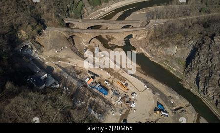 Altenahr, Deutschland. 25. März 2022. Vor dem Tunnel in Altenahr laufen die Bauarbeiten an der Rotweinstraße, die durch das Ahrtal verläuft (Luftaufnahme mit Drohne), in vollem Gange. Die Überschwemmung im Juli 2021 hat die landschaftlich reizvolle Route (B 267) bei Altenahr neben einem Tunnel komplett weggefegt. (Nach dpa: Rotweinstraße im Ahr-Hochwassergebiet nur im Sommer befahrbar). Quelle: Thomas Frey/dpa/Alamy Live News Stockfoto