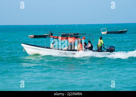 Sansibar, Tansania - Januar 02,2022: Touristen kehren mit dem Boot von der Insel Sansibar zum Strand der Pongwe Bay zurück. Stockfoto