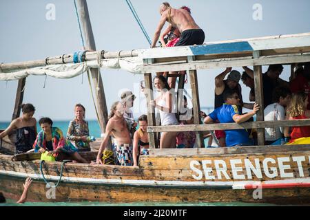 Sansibar, Tansania - Januar 02,2022: Touristen kehren mit dem Boot von der Insel Sansibar zum Strand der Pongwe Bay zurück. Stockfoto