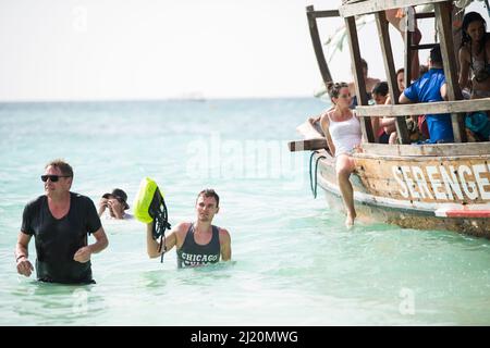 Sansibar, Tansania - Januar 02,2022: Touristen kehren mit dem Boot von der Insel Sansibar zum Strand der Pongwe Bay zurück. Stockfoto