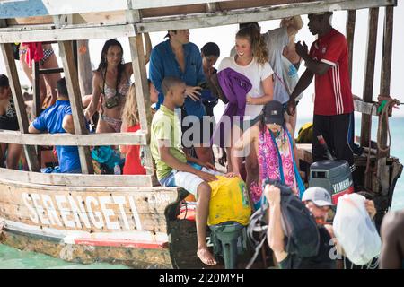 Sansibar, Tansania - Januar 02,2022: Touristen kehren mit dem Boot von der Insel Sansibar zum Strand der Pongwe Bay zurück. Stockfoto