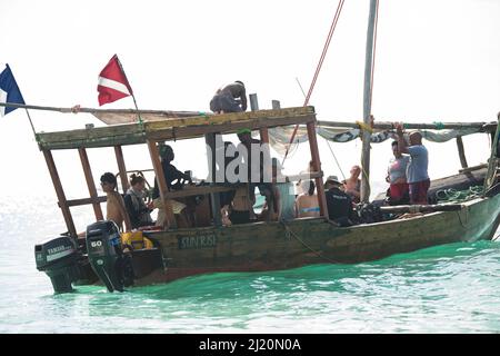 Sansibar, Tansania - Januar 02,2022: Touristen kehren mit dem Boot von der Insel Sansibar zum Strand der Pongwe Bay zurück. Stockfoto