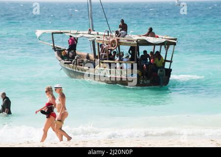 Sansibar, Tansania - Januar 02,2022: Touristen kehren mit dem Boot von der Insel Sansibar zum Strand der Pongwe Bay zurück. Stockfoto