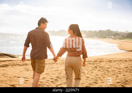 Junges Paar, das am Strand spazieren geht - Stock Photo Stockfoto