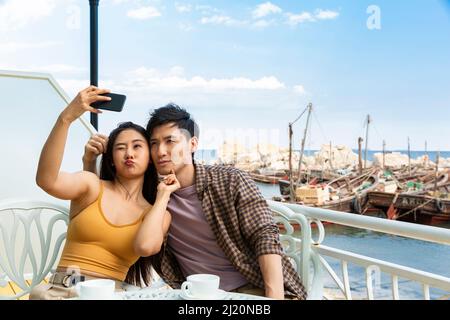 Paare machen gerne Selfies in einem Café am Meer - Stock Photo Stockfoto