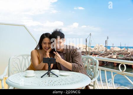Junges Paar chattet mit dem Handy im Restaurant Ocean View - Stock photo Stockfoto