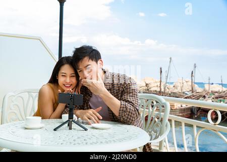 Junges Paar chattet mit dem Handy im Restaurant Ocean View - Stock photo Stockfoto