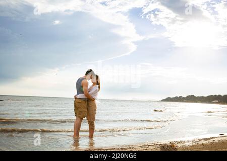 Ein junges Paar umarmen, das barfuß am Meer steht - Stock photo Stockfoto