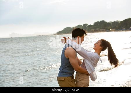 Ein junges Paar umarmen, das barfuß am Meer steht - Stock photo Stockfoto