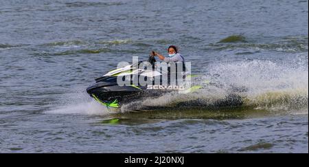 Nuwara Eliya, Sri Lanka - 02 16 2022: Frauen fahren auf einem Jetski in Gregory Lake. Wasser spritzt, während sie Stunts im Wasser durchführt. Stockfoto