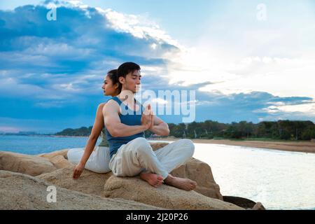 Paare üben Yoga Achtsamkeit auf Insel Felsen - Stock Foto Stockfoto