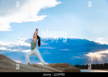 Schöne junge Dame, die Yoga am Strandriff praktiziert - Stock Foto Stockfoto