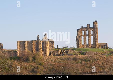 Tynemouth Castle liegt auf einer felsigen Landzunge mit Blick auf den Tynemouth Pier. Die Wassertürme, das Torhaus und der Wachturm werden mit den Ruinen kombiniert Stockfoto