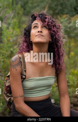 Porträt einer Frau, die im Freien in der Natur sitzt Stockfoto