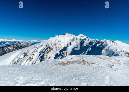 Chopok Hügel in Nizke Tatry Berge und Gipfel der Zapadne und Vysoke Tatry Berge während erstaunlichen Wintertag Stockfoto