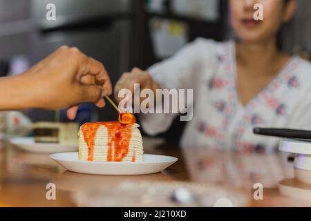 Glückliche Familie Hand mit Löffel genießen Sie zu Hause Crape Kuchen zu essen. Stockfoto