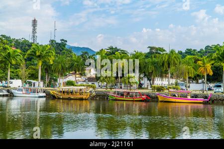 Eine schöne Aufnahme von kleinen Touristenbooten im Haupthafen von Paraty mit Bergen im Hintergrund Stockfoto