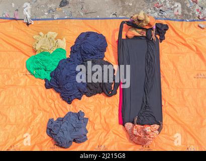 Narayanganj, Dhaka, Bangladesch. 29. März 2022. In Narayanganj, Bangladesch, sortieren Arbeiter bunte Stoffstapel, die zu Kleidungsstücken verarbeitet werden. Die Arbeiter sortieren und wählen die Stoffe nach Farbe, Qualität und der Nachfrage der Käufer aus. Die Stoffe werden in der Regel bei der Herstellung von Bekleidung verwendet. Sie werden für die Sortierung und Sortierung sowie zum Trocknen in der Sonne aufgeschichtet, wobei Feuchtigkeit aus dem Sterbeprozess entfernt wird. (Bild: © Joy Saha/ZUMA Press Wire) Stockfoto