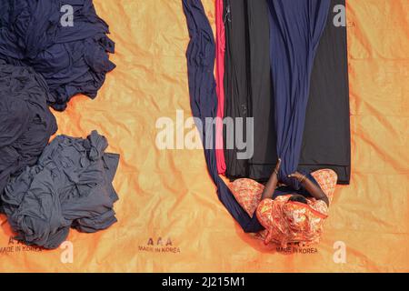 Narayanganj, Dhaka, Bangladesch. 29. März 2022. In Narayanganj, Bangladesch, sortieren Arbeiter bunte Stoffstapel, die zu Kleidungsstücken verarbeitet werden. Die Arbeiter sortieren und wählen die Stoffe nach Farbe, Qualität und der Nachfrage der Käufer aus. Die Stoffe werden in der Regel bei der Herstellung von Bekleidung verwendet. Sie werden für die Sortierung und Sortierung sowie zum Trocknen in der Sonne aufgeschichtet, wobei Feuchtigkeit aus dem Sterbeprozess entfernt wird. (Bild: © Joy Saha/ZUMA Press Wire) Stockfoto