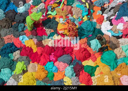 Narayanganj, Dhaka, Bangladesch. 29. März 2022. In Narayanganj, Bangladesch, sortieren Arbeiter bunte Stoffstapel, die zu Kleidungsstücken verarbeitet werden. Die Arbeiter sortieren und wählen die Stoffe nach Farbe, Qualität und der Nachfrage der Käufer aus. Die Stoffe werden in der Regel bei der Herstellung von Bekleidung verwendet. Sie werden für die Sortierung und Sortierung sowie zum Trocknen in der Sonne aufgeschichtet, wobei Feuchtigkeit aus dem Sterbeprozess entfernt wird. (Bild: © Joy Saha/ZUMA Press Wire) Stockfoto