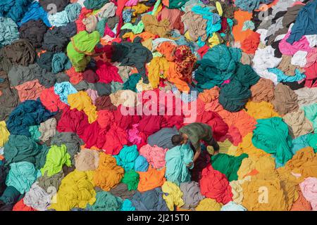 Narayanganj, Dhaka, Bangladesch. 29. März 2022. In Narayanganj, Bangladesch, sortieren Arbeiter bunte Stoffstapel, die zu Kleidungsstücken verarbeitet werden. Die Arbeiter sortieren und wählen die Stoffe nach Farbe, Qualität und der Nachfrage der Käufer aus. Die Stoffe werden in der Regel bei der Herstellung von Bekleidung verwendet. Sie werden für die Sortierung und Sortierung sowie zum Trocknen in der Sonne aufgeschichtet, wobei Feuchtigkeit aus dem Sterbeprozess entfernt wird. (Bild: © Joy Saha/ZUMA Press Wire) Stockfoto