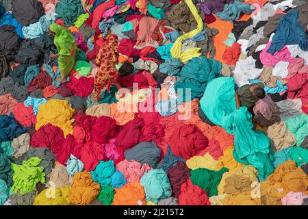 Narayanganj, Dhaka, Bangladesch. 29. März 2022. In Narayanganj, Bangladesch, sortieren Arbeiter bunte Stoffstapel, die zu Kleidungsstücken verarbeitet werden. Die Arbeiter sortieren und wählen die Stoffe nach Farbe, Qualität und der Nachfrage der Käufer aus. Die Stoffe werden in der Regel bei der Herstellung von Bekleidung verwendet. Sie werden für die Sortierung und Sortierung sowie zum Trocknen in der Sonne aufgeschichtet, wobei Feuchtigkeit aus dem Sterbeprozess entfernt wird. (Bild: © Joy Saha/ZUMA Press Wire) Stockfoto