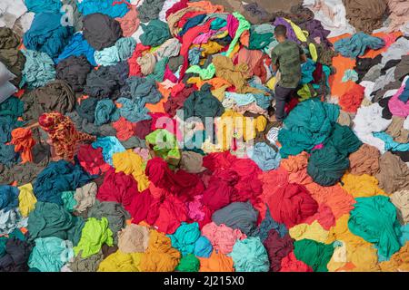 Narayanganj, Dhaka, Bangladesch. 29. März 2022. In Narayanganj, Bangladesch, sortieren Arbeiter bunte Stoffstapel, die zu Kleidungsstücken verarbeitet werden. Die Arbeiter sortieren und wählen die Stoffe nach Farbe, Qualität und der Nachfrage der Käufer aus. Die Stoffe werden in der Regel bei der Herstellung von Bekleidung verwendet. Sie werden für die Sortierung und Sortierung sowie zum Trocknen in der Sonne aufgeschichtet, wobei Feuchtigkeit aus dem Sterbeprozess entfernt wird. (Bild: © Joy Saha/ZUMA Press Wire) Stockfoto