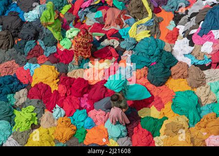 Narayanganj, Dhaka, Bangladesch. 29. März 2022. In Narayanganj, Bangladesch, sortieren Arbeiter bunte Stoffstapel, die zu Kleidungsstücken verarbeitet werden. Die Arbeiter sortieren und wählen die Stoffe nach Farbe, Qualität und der Nachfrage der Käufer aus. Die Stoffe werden in der Regel bei der Herstellung von Bekleidung verwendet. Sie werden für die Sortierung und Sortierung sowie zum Trocknen in der Sonne aufgeschichtet, wobei Feuchtigkeit aus dem Sterbeprozess entfernt wird. (Bild: © Joy Saha/ZUMA Press Wire) Stockfoto