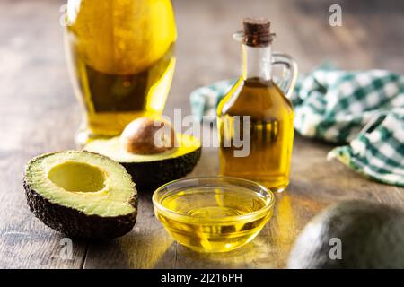Öl und reife frische Avocado auf rustikalem Holztisch Stockfoto