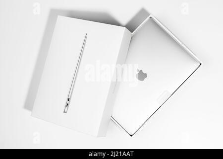 Saratov, Russland - 26. Februar 2022: Demonstration des neuen Macbook Air 13 Zoll mit M1 Prozessor in stilvoller Verpackung, flach liegend, weißer Hintergrund Stockfoto
