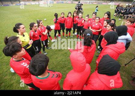 Spieler der Afghanistan Development Squad während eines Teamgespräches vor ihrem Spiel gegen die Parlamentarische Frauenmannschaft im Dulwich Hamlet Football Club, Süd-London. Amnesty International UK startet seinen Fußball-Willkommensmonat – eine Initiative zur Aufnahme von Flüchtlingen und Asylsuchenden in die britischen Gemeinden – durch die Durchführung eines Fußballspiels zwischen dem afghanischen Entwicklungskommando und der parlamentarischen Frauenmannschaft. Bilddatum: Dienstag, 29. März 2022. Stockfoto