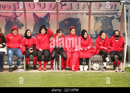 Spieler der Afghanistan Development Squad sitzen während eines Spiels gegen das Parlamentarische Frauenteam im Dulwich Hamlet Football Club, Süd-London, auf der Bank. Amnesty International UK startet seinen Fußball-Willkommensmonat – eine Initiative zur Aufnahme von Flüchtlingen und Asylsuchenden in die britischen Gemeinden – durch die Durchführung eines Fußballspiels zwischen dem afghanischen Entwicklungskommando und der parlamentarischen Frauenmannschaft. Bilddatum: Dienstag, 29. März 2022. Stockfoto