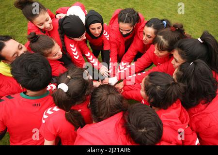 Die Spieler der Afghanistan Development Squad legten ihre Hände zusammen, bevor sie im Dulwich Hamlet Football Club im Süden Londons gegen das Parlamentarische Frauenteam antreten. Amnesty International UK startet seinen Fußball-Willkommensmonat – eine Initiative zur Aufnahme von Flüchtlingen und Asylsuchenden in die britischen Gemeinden – durch die Durchführung eines Fußballspiels zwischen dem afghanischen Entwicklungskommando und der parlamentarischen Frauenmannschaft. Bilddatum: Dienstag, 29. März 2022. Stockfoto