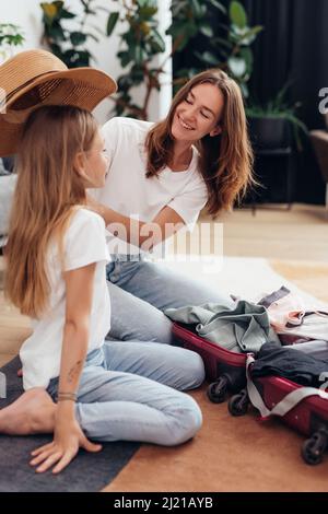 Mutter und Tochter gehen auf Reise Koffer packen. Stockfoto
