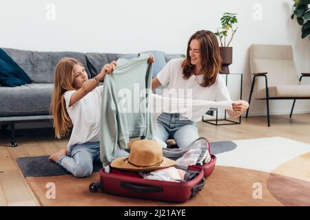 Mutter und Tochter gehen auf Reise Koffer packen. Stockfoto