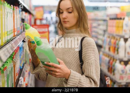 Junge Frau wählt eine Klimaanlage oder eine Waschmaschine gel in einem Laden. Stockfoto