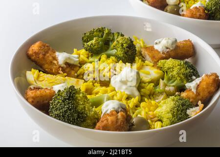 Fischfinger mit gelbem Reis und Brokkoli - herzhaftes rustikales Rezept mit Fischstäbchen mit selektivem Fokus Stockfoto