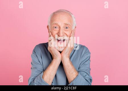 Foto von älteren weißen Frisur Mann Hände Gesicht tragen blaues Hemd isoliert auf rosa Hintergrund Stockfoto