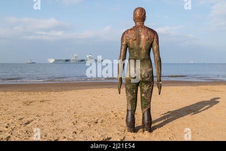 Iron man blickt auf die HMS Queen Elizabeth, als der neue Flugzeugträger der Royal Navy Liverpool verlässt und vom Crosby Beac aus auf See geht Stockfoto